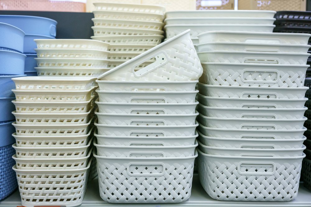 Stacked white plastic baskets displayed on store shelf