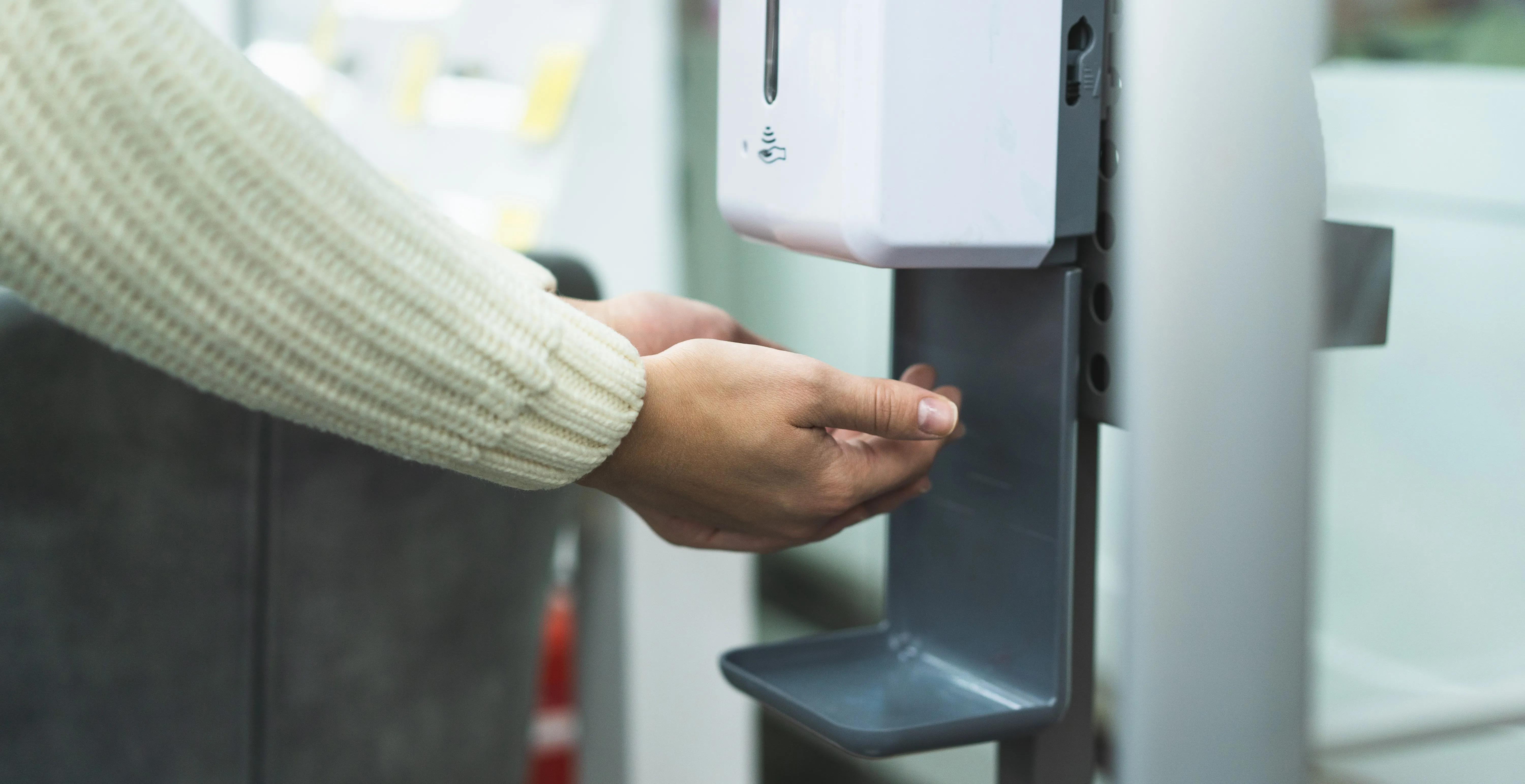 person using automated sanitizer