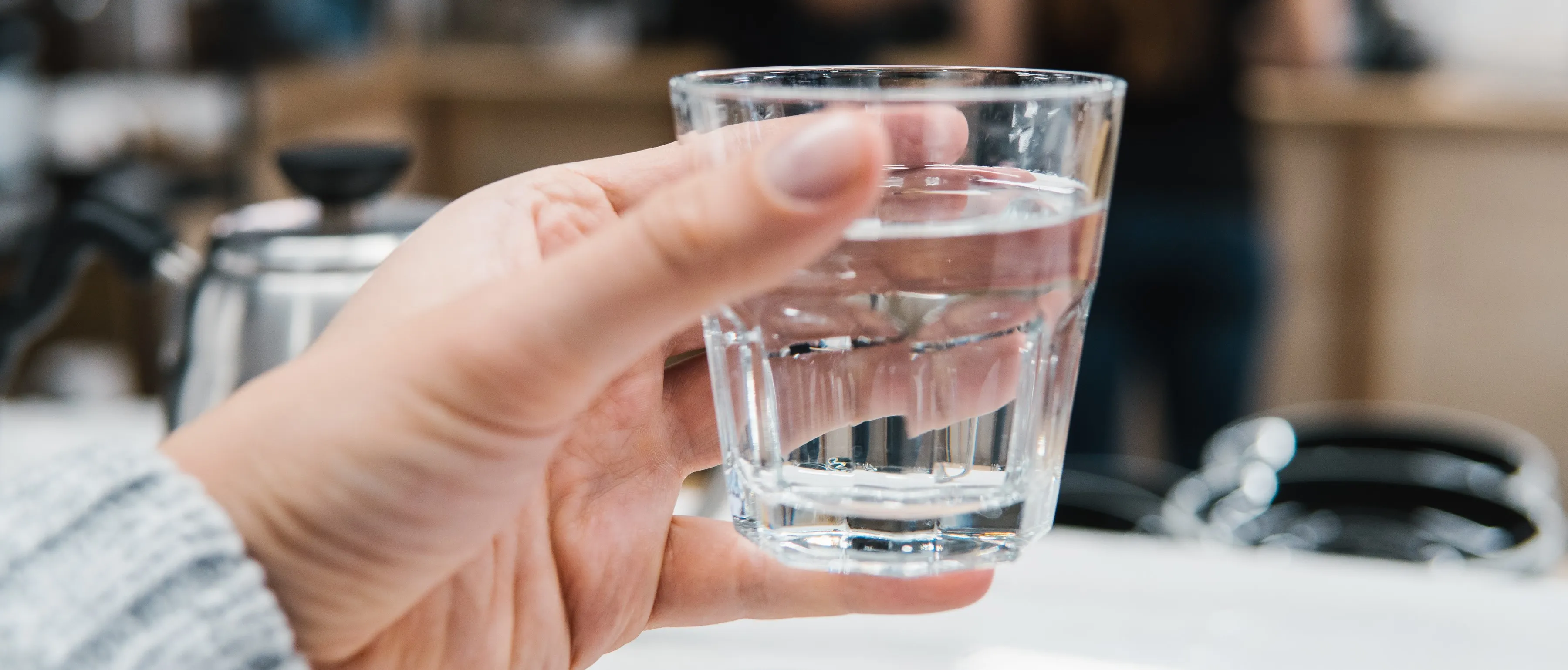 hand holding full glass of water