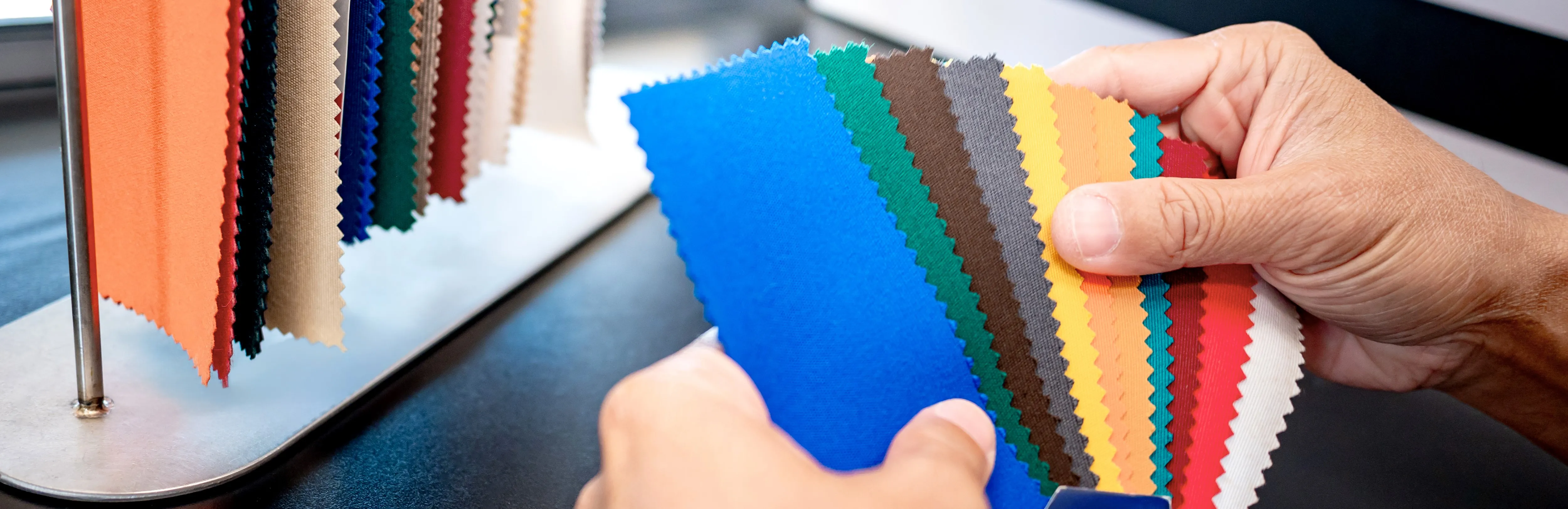 hands holding colorful fabric swatches for textile selection